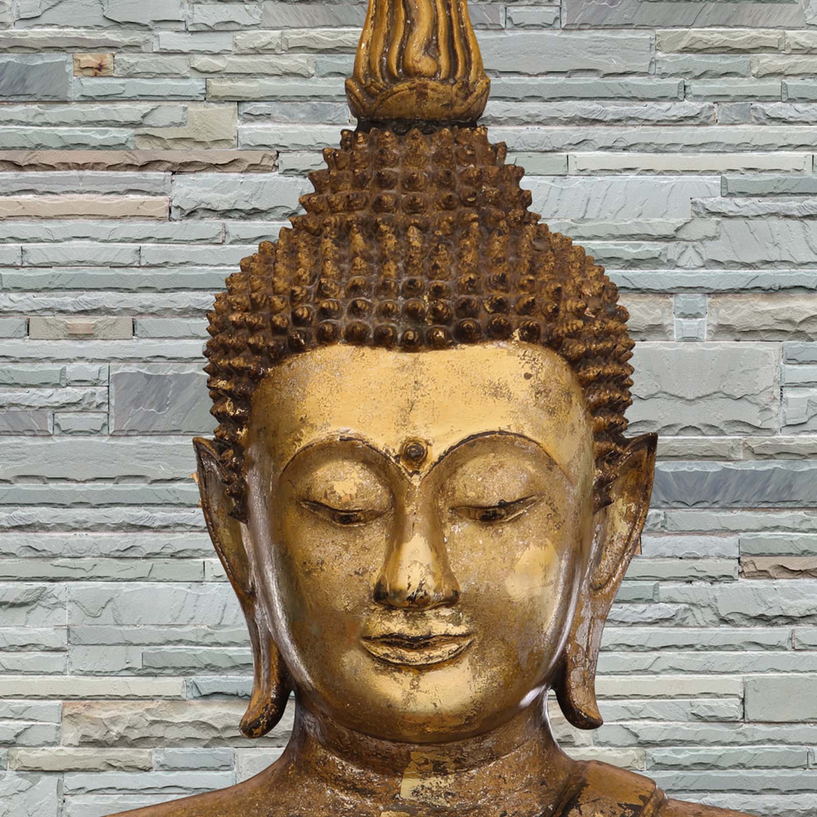 A close-up of aBronze Buddha on Slate Background Wallpaper for Room Walls, Customised Indrani Series Canvas Texture Design (Customised Size Wallpaper )available at Material Depot in Bangalore