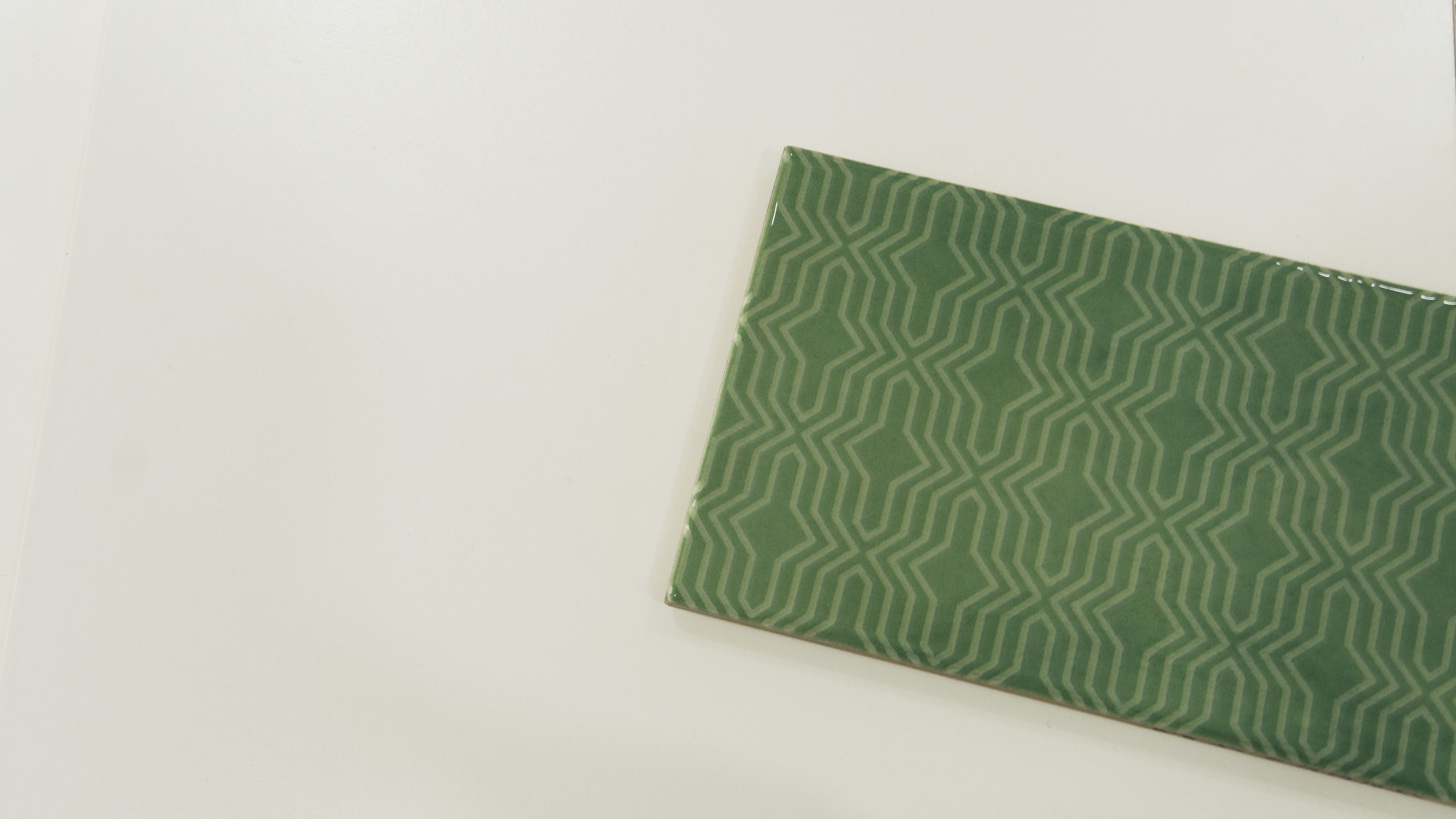 A close-up of a TL 03799 B Green Geo 300x100 mm Glossy Finish Ceramic Wall  Subway Tile - 10 mm  with a Glossy finish available at Material Depot in Bangalore