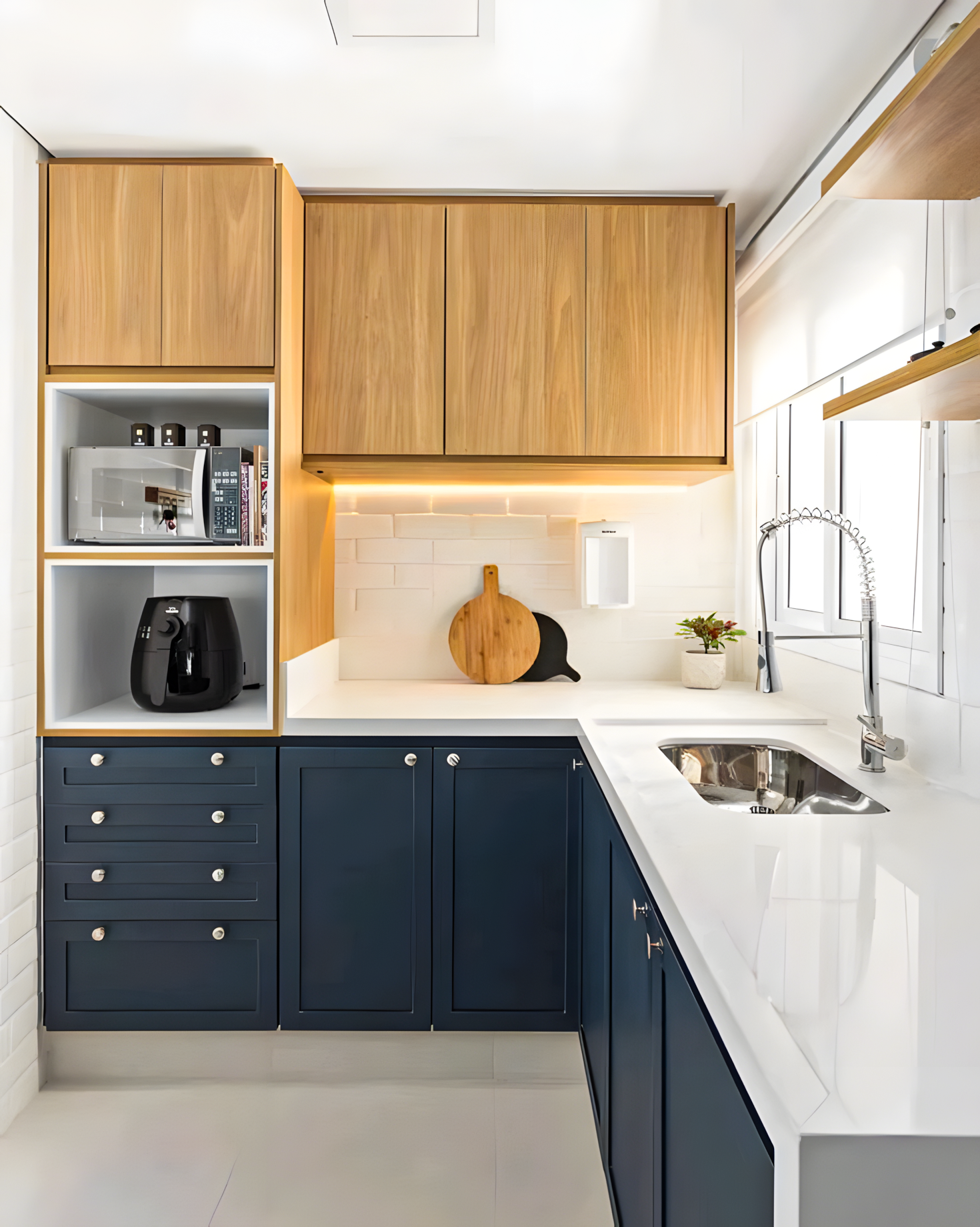 Compact kitchen with sleek navy lower cabinets, white quartz countertop, and warm wood accents. | Material Depot