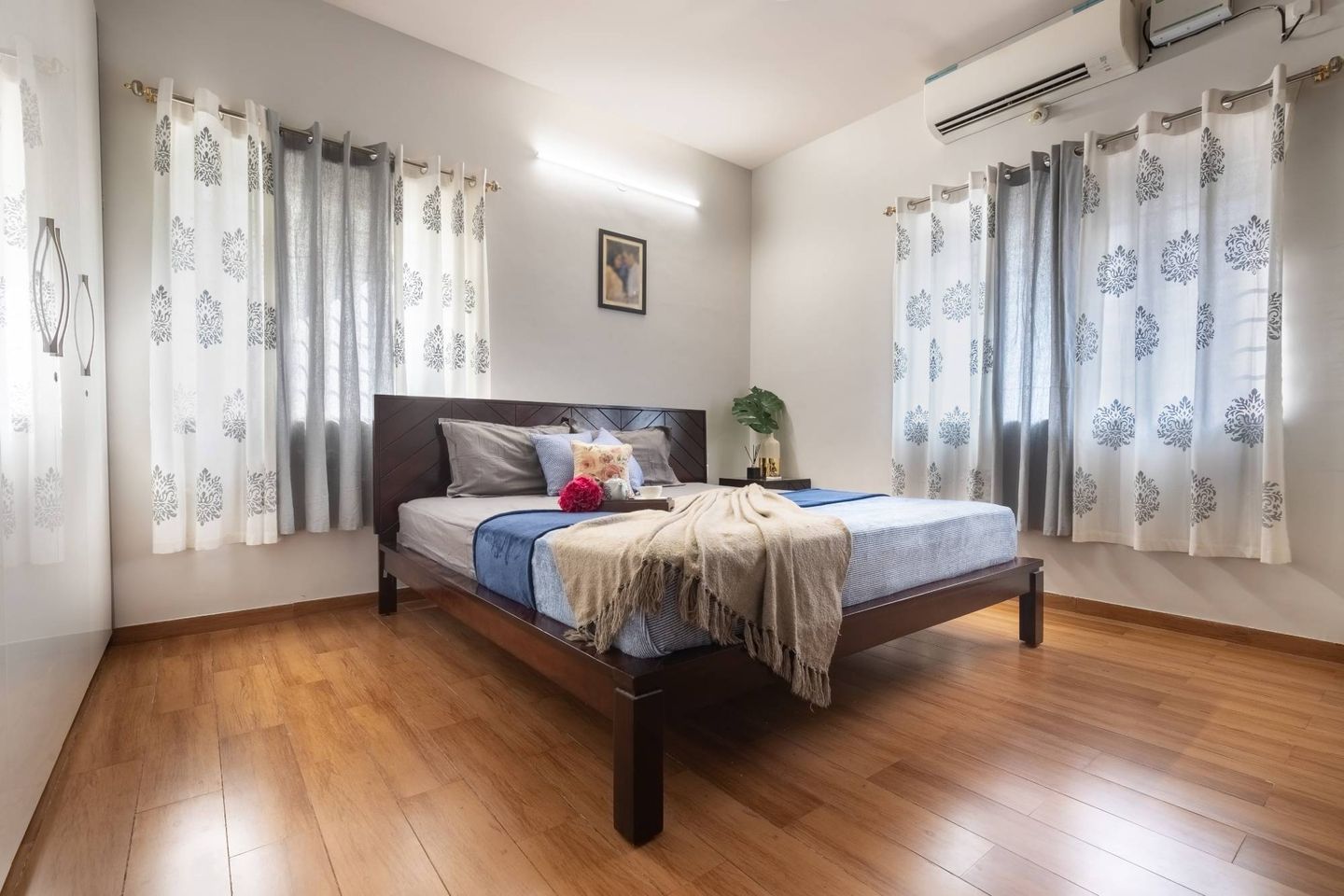 Master bedroom with wooden laminate flooring and light grey walls