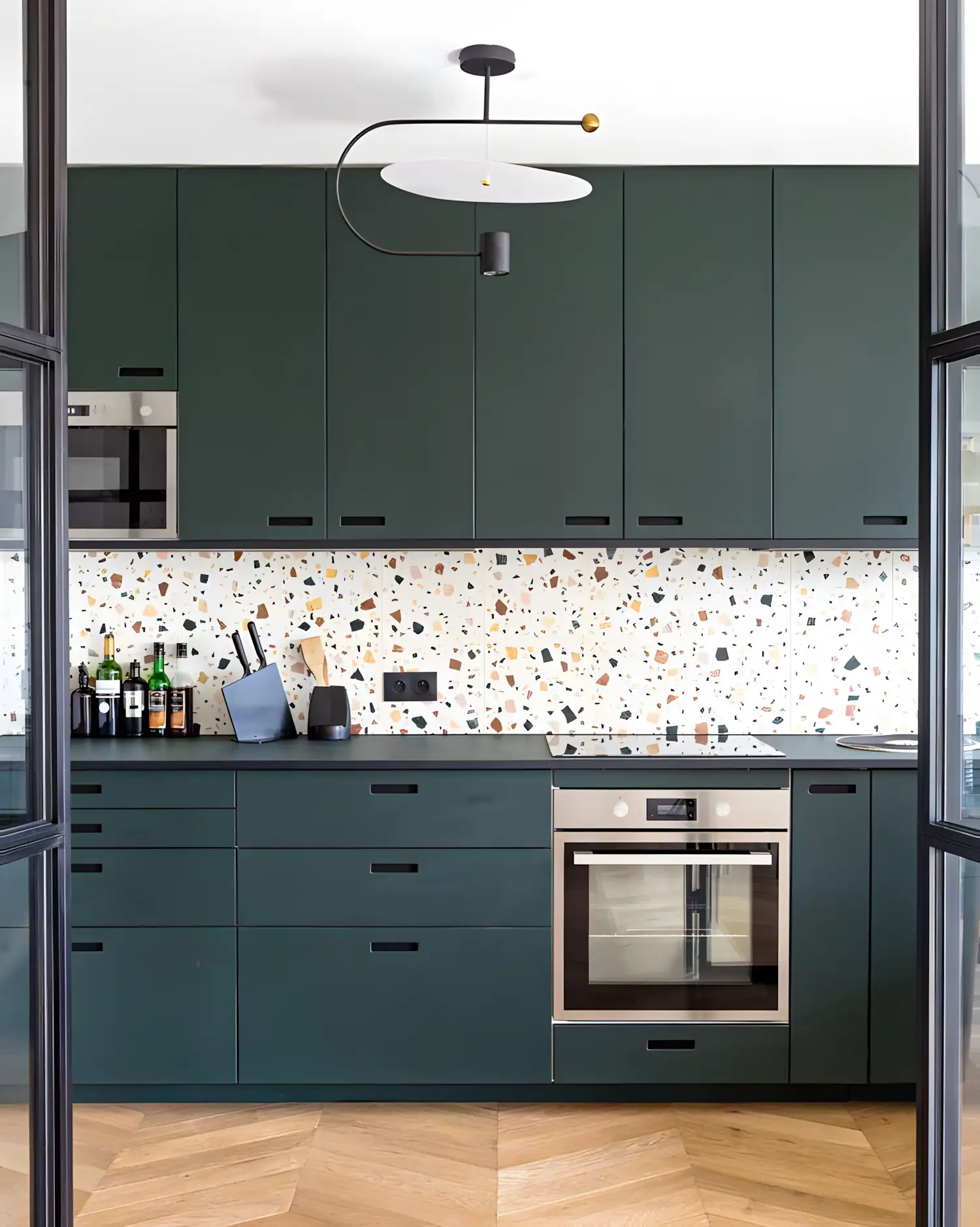 Stylish Kitchen Featuring Green Cabinets and Vibrant Terrazzo Backsplash | Material Depot